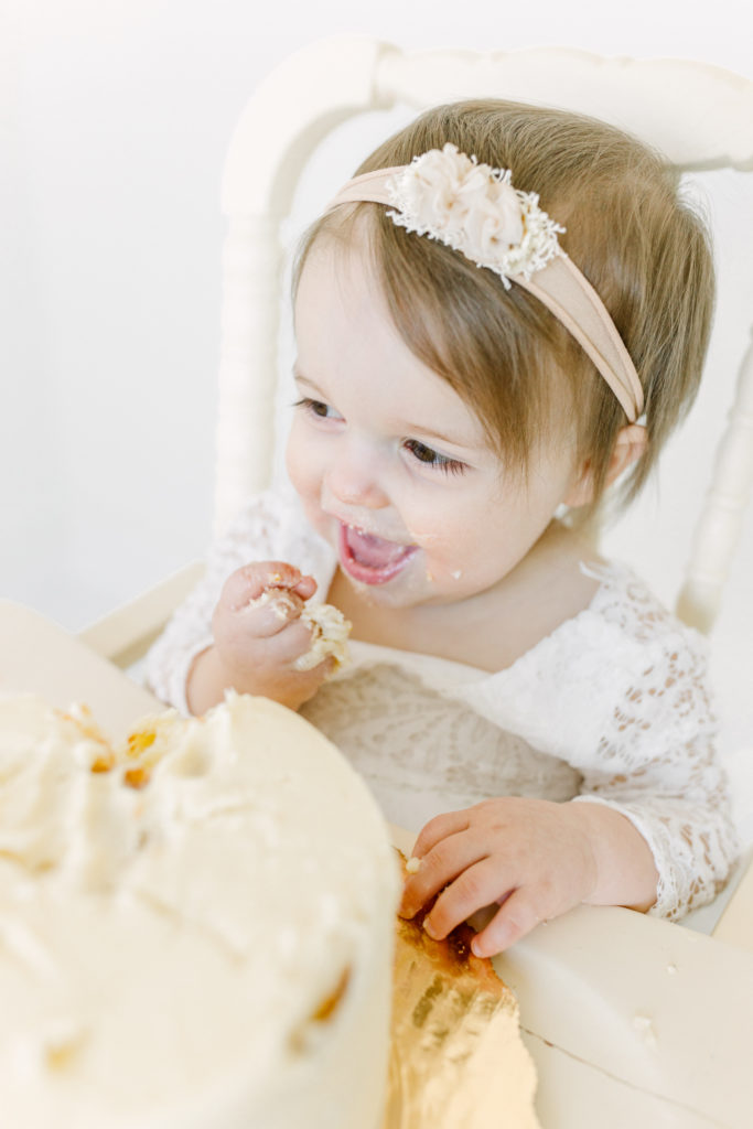 Baby eating cake at her 1st Birthday Cake Smash at Spencer Livingston Photography Studio