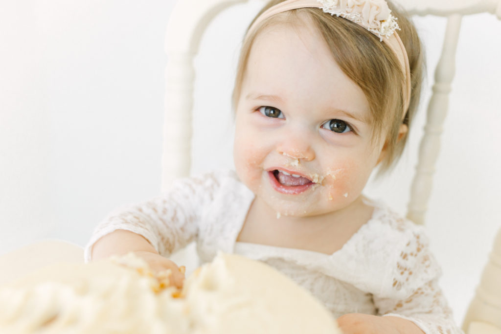 Smiling Baby at her cake smash 1st birthday session 