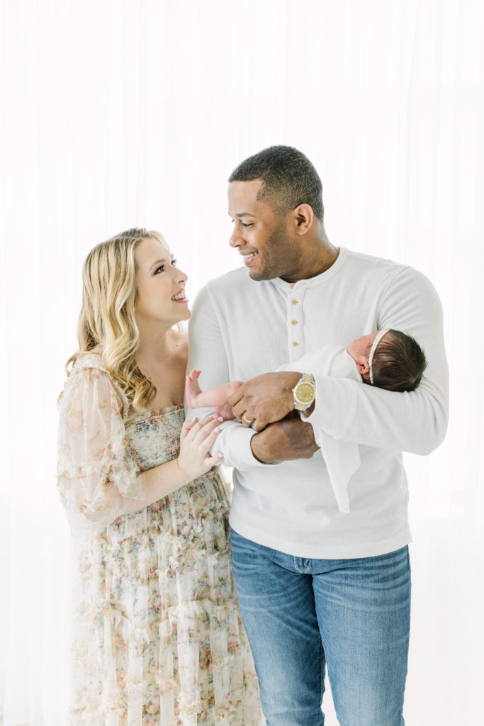 Mom and Dad smile at each other during Atlanta newborn photography session.